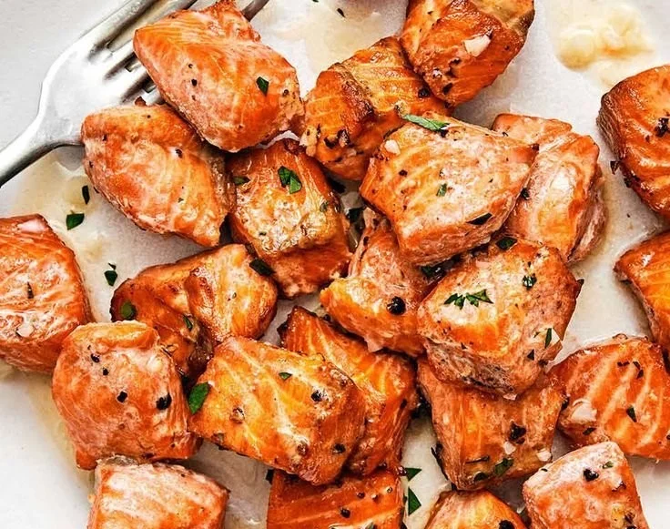 Delicious air fryer salmon bites served with lemon garlic butter sauce.