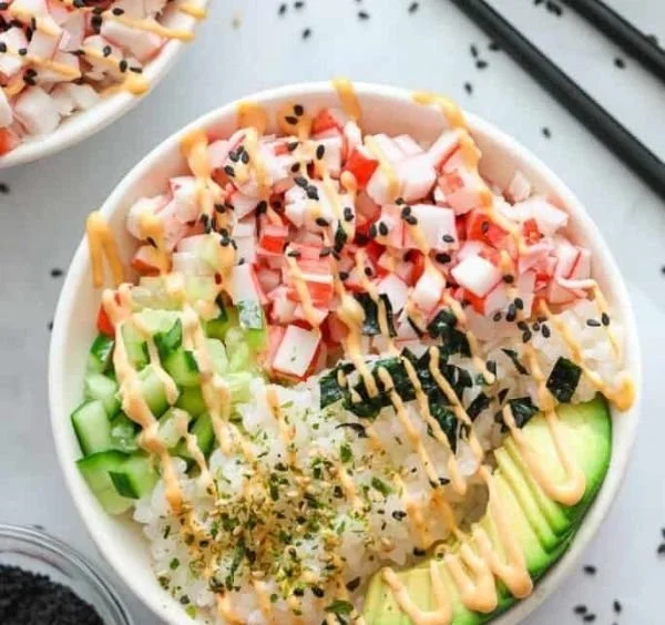 California roll sushi bowl topped with fresh avocado and crab sticks