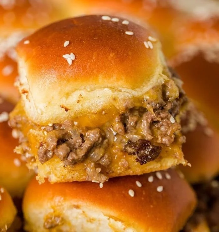 Delicious cheeseburger sliders served on a wooden platter with toppings