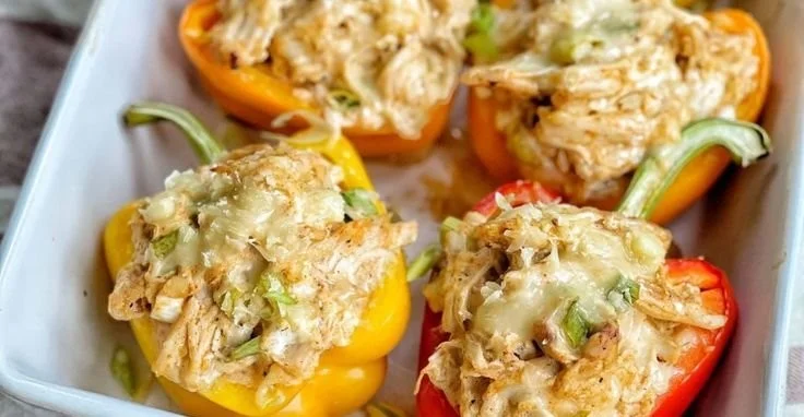 Plate of chicken stuffed peppers topped with cheese and herbs
