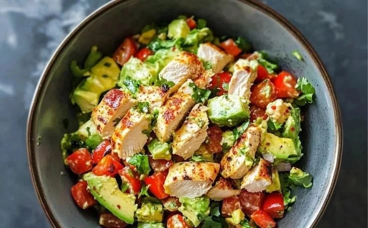 Creamy avocado chicken salad served in a bowl with garnishes