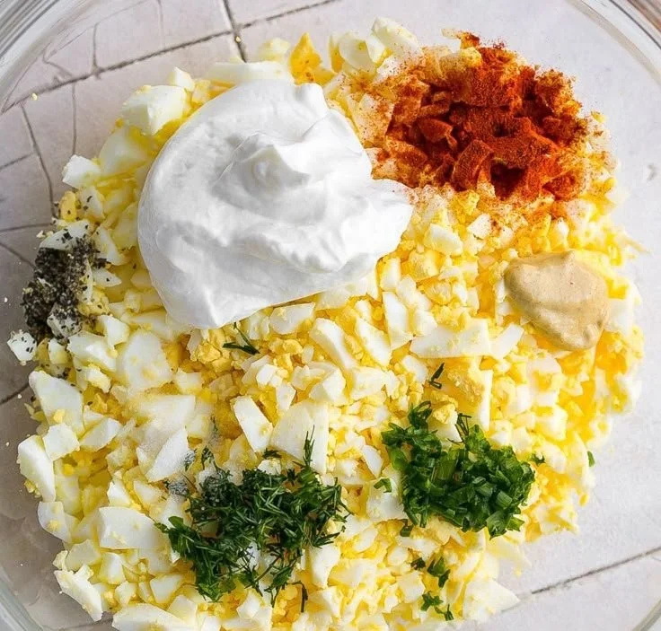 Creamy egg salad with dill served on a plate with fresh herbs