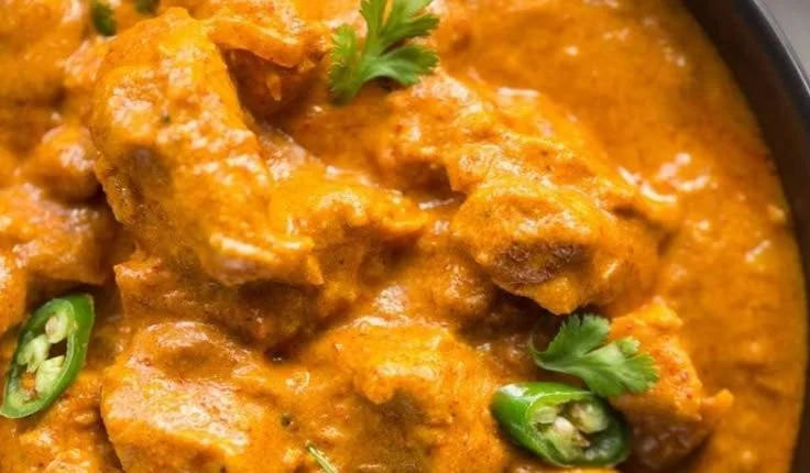 Bowl of Crockpot Coconut Curry Chicken garnished with herbs