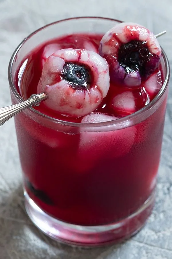Spooky Eyeball Gin Cocktail served in a glass with ice and eyeball garnish