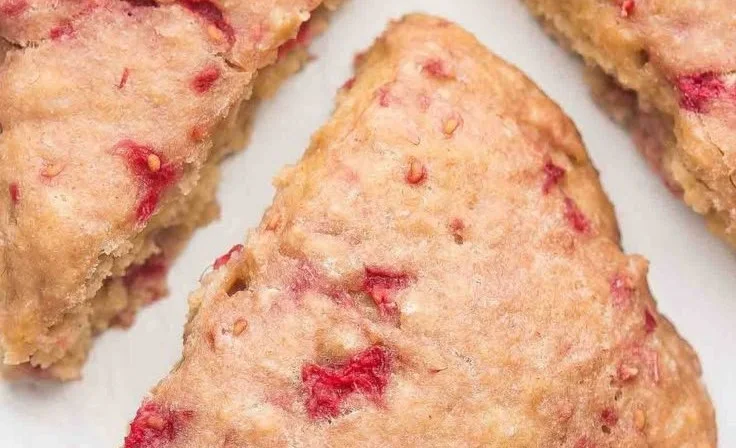 Healthy raspberry almond scones served on a plate with fresh raspberries