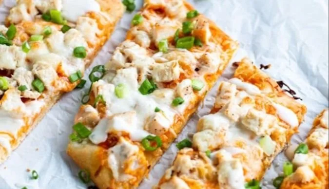 High protein buffalo chicken flatbread topped with cheese and veggies