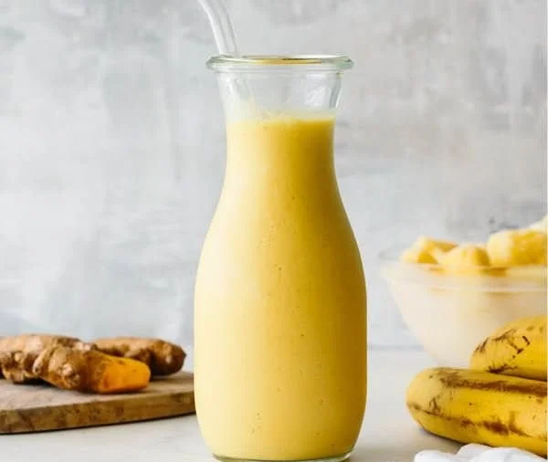 Colorful inflammation-reducing smoothie ingredients and finished glass of smoothie.