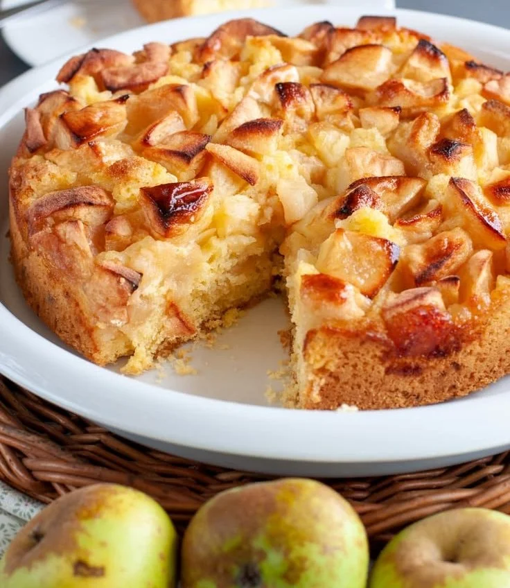 Delicious Italian apple cake served on a plate with a slice cut out