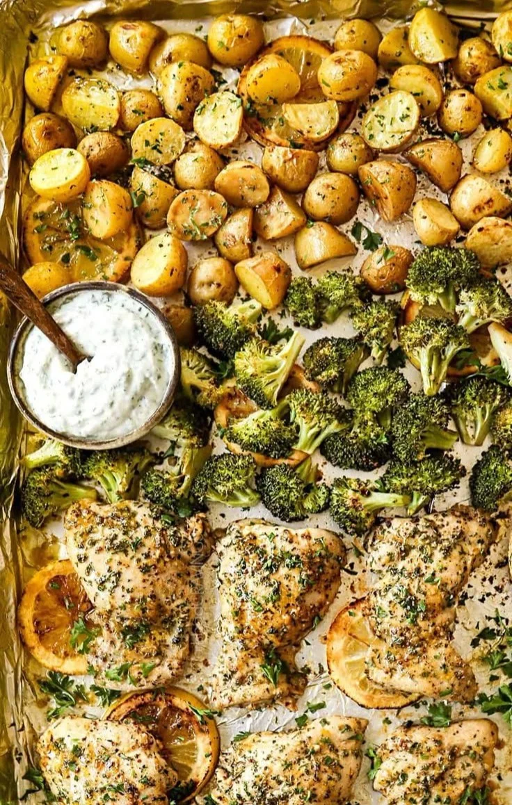 Lemon garlic chicken thighs served with broccoli and roasted potatoes on a plate.