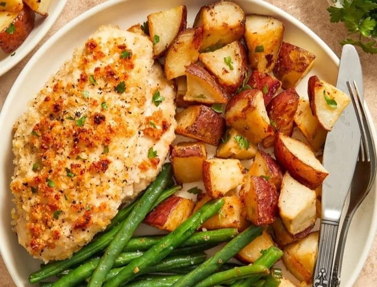 A sheet pan with parmesan-crusted chicken and roasted vegetables.